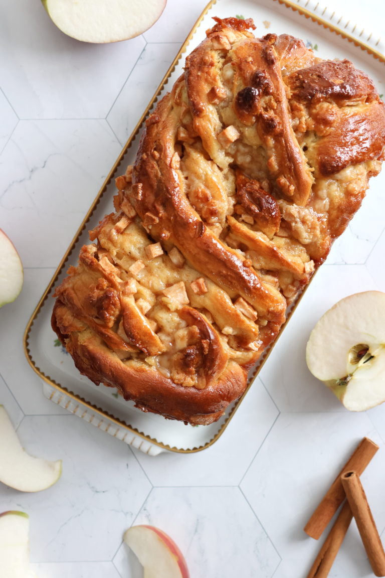 Apple Marzipan Babka on a serving dish with some cut apples on the side.