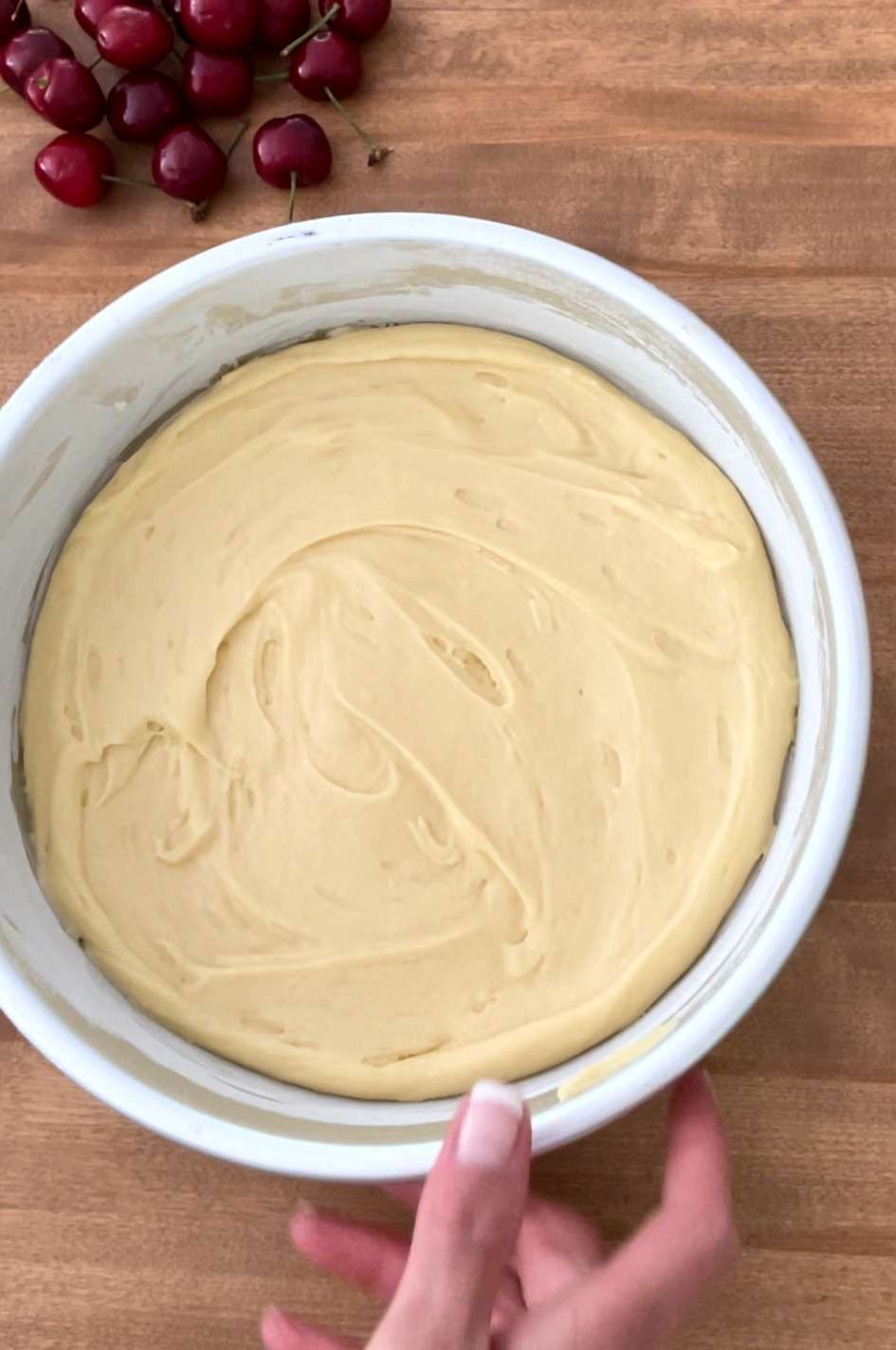 White forest cake batter in a floured cake pan before baking.