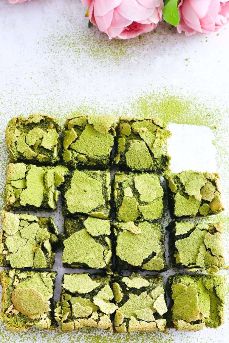 Matcha lemon squares with crinkly tops and on square missing.