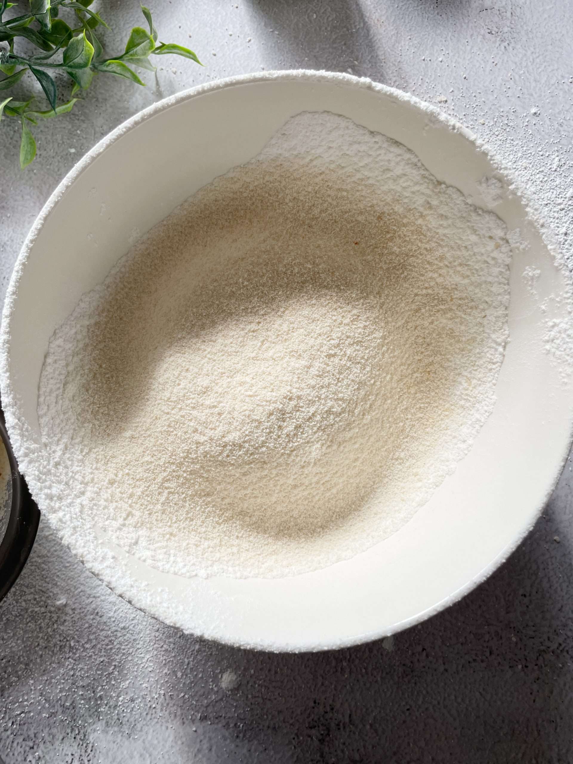 Almond flour and all-purpose flour in a white mixing bowl.