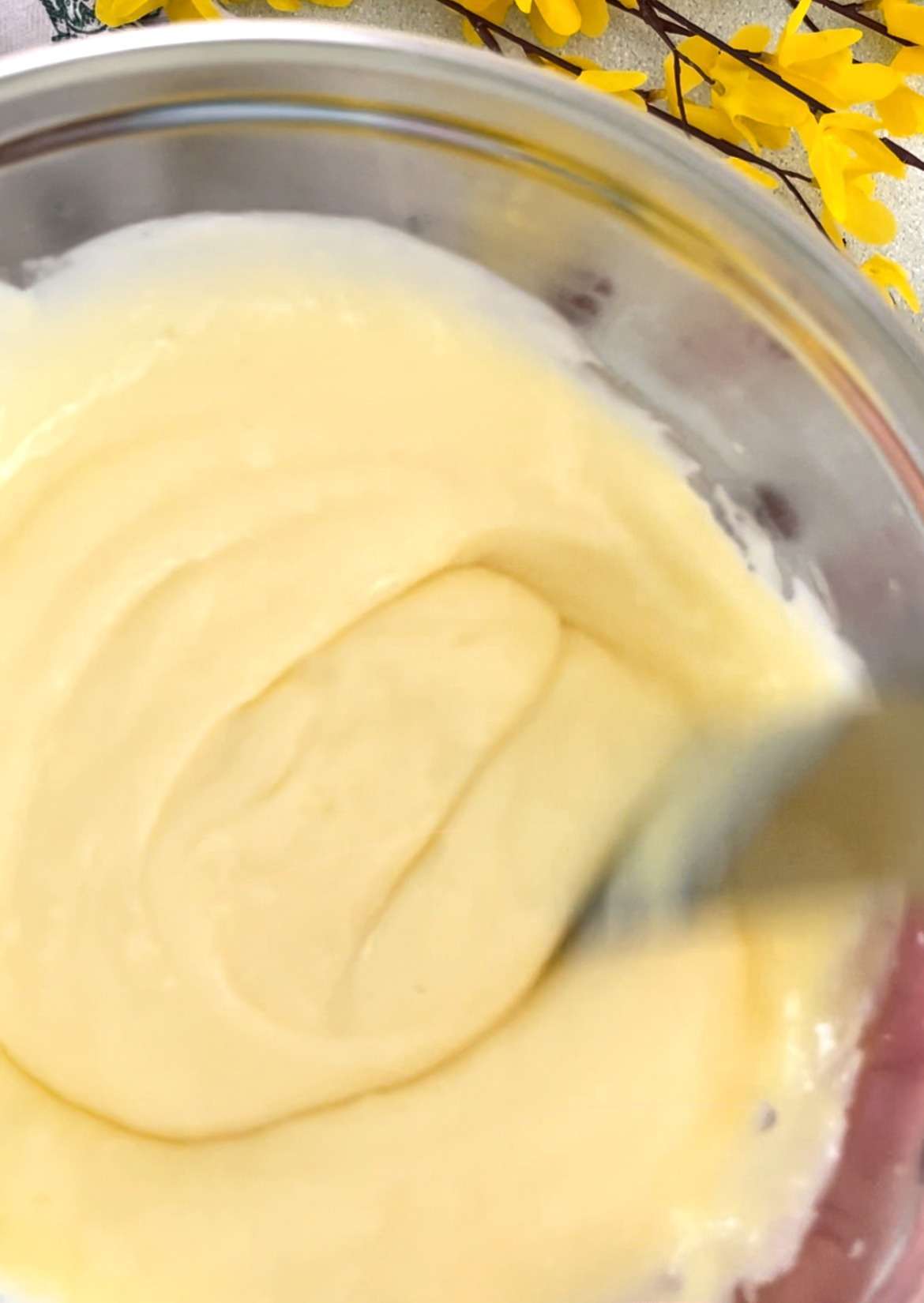 Smooth pastry cream being stirred in a bowl.