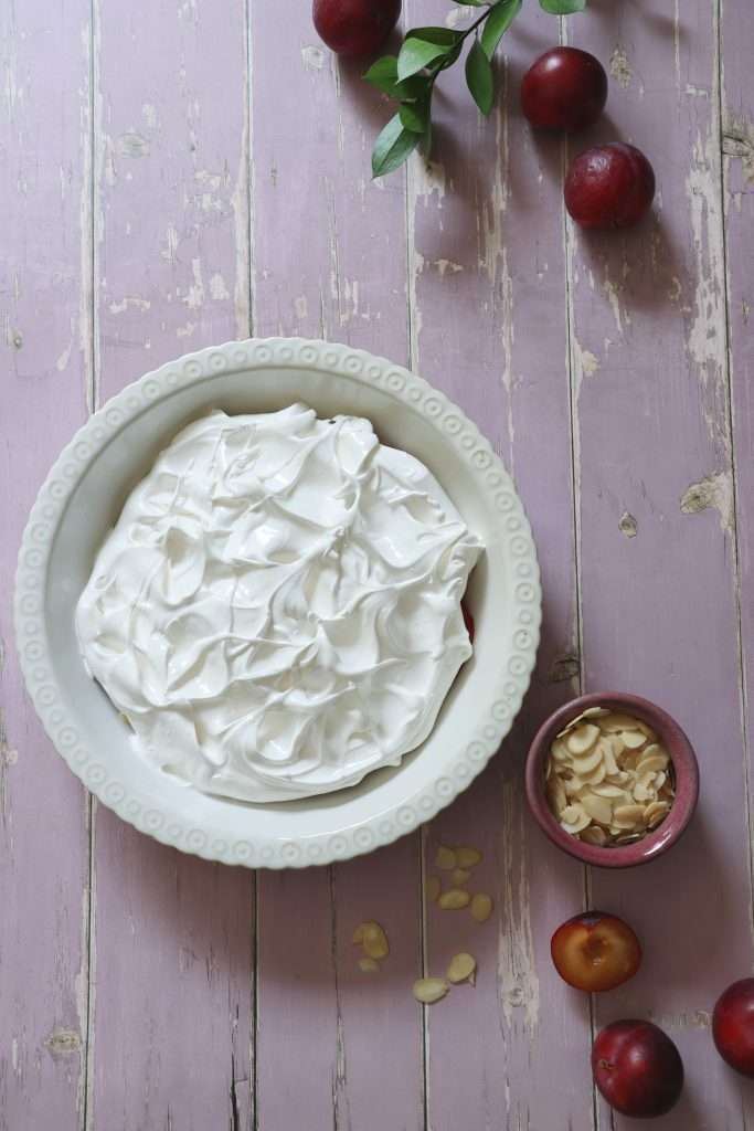 Swiss Plum Meringue (Zwetschgen) with Toasted Almond Base 9 Fluffy and delicate Swiss meringue topping swirled over the cooked plum layer before baking.