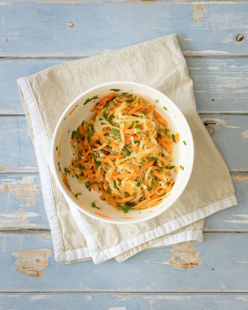 Spring Carrot Rösti Recipe with Lemon and Herbs 21 Grated potatoes and carrots in a bowl, mixed with herbs and lemon rind.