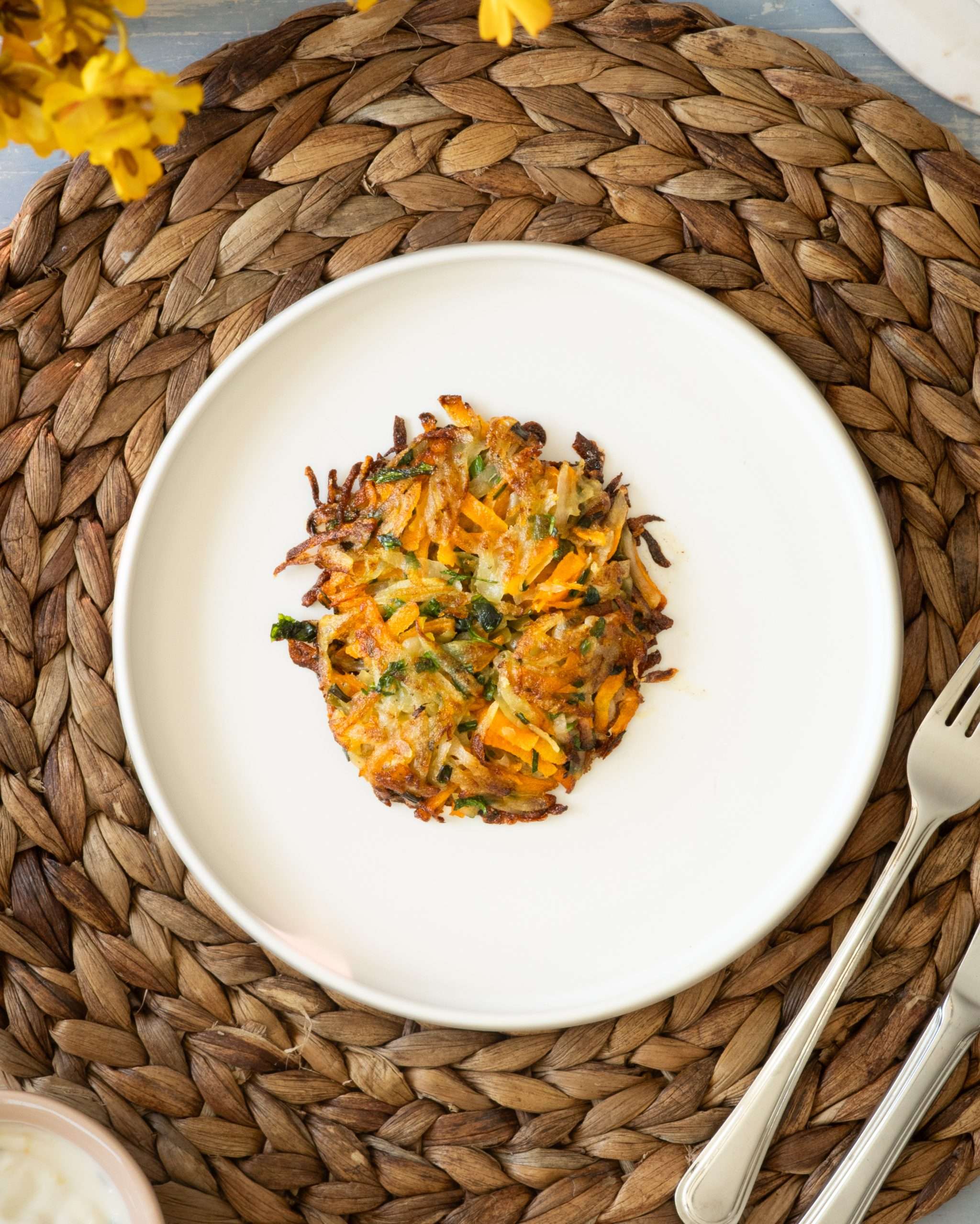Spring Carrot Rösti Recipe with Lemon and Herbs 35 A mini carrot and potato rosti sitting on a white plate.