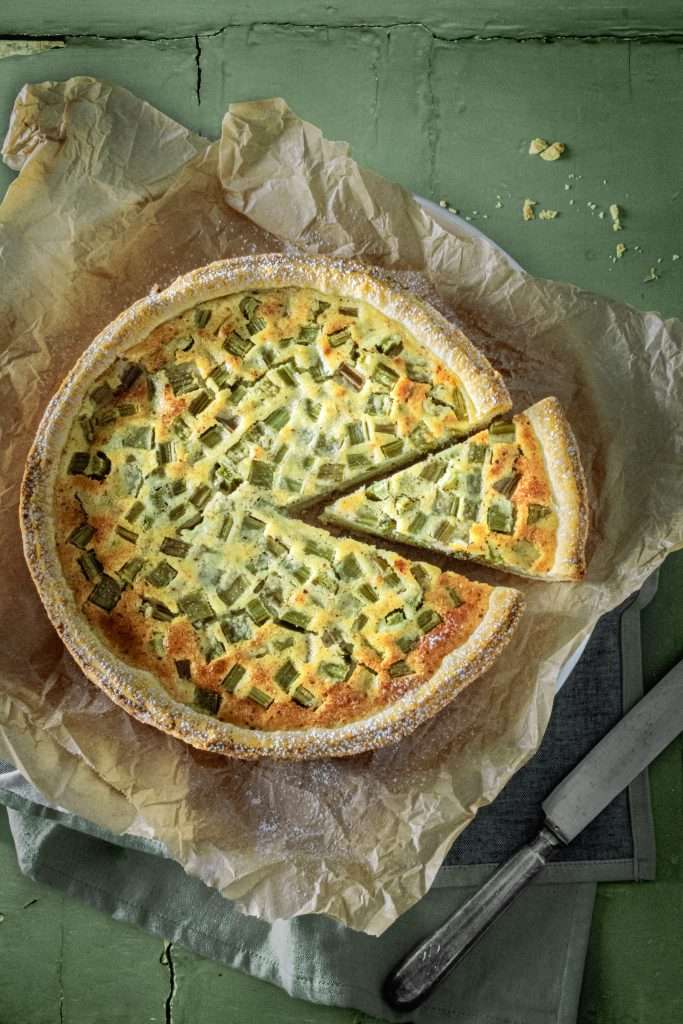 Swiss rhubarb custard tart, Rhabarberwähe, with a slice cut.
