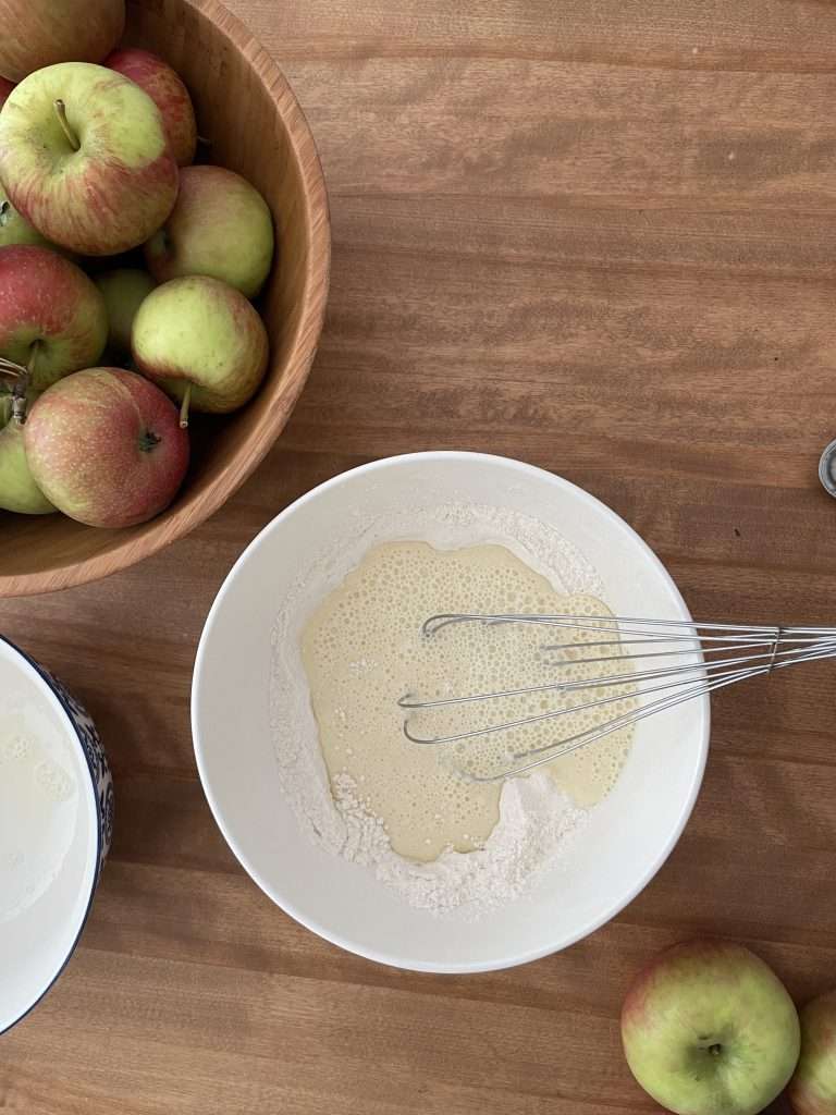 Batter in a bowl to dip apple rings into to make Apfelkuchlein.