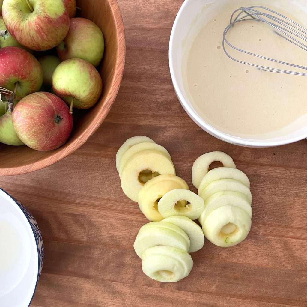 Peeled apples cut into rings to make Apfelküchlein.