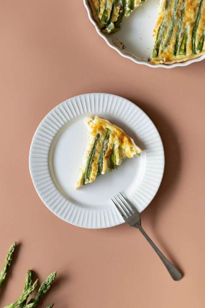 A slice of asparagus tart on a plate.