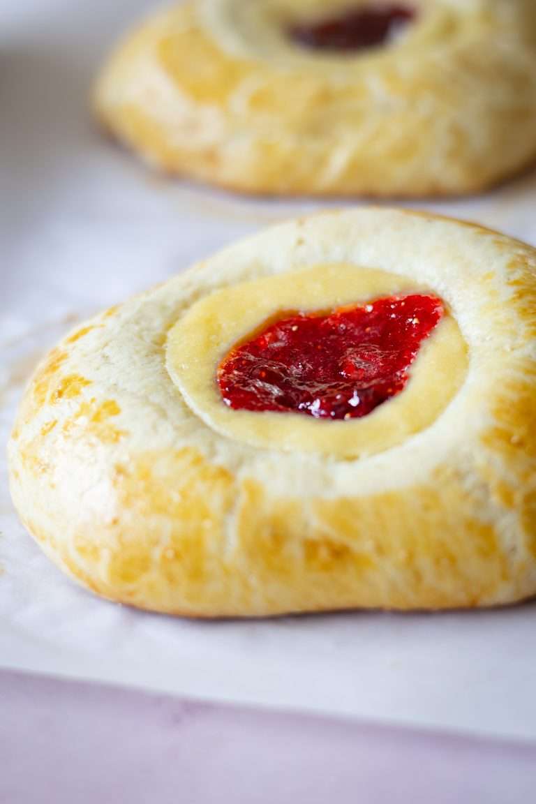 Close-up of a soft brioche bun with a vanilla cream and strawberry rhubarb center.