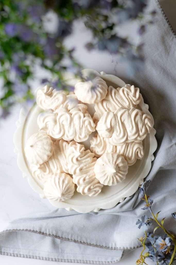 Homemade Coffee Ice Cream with Chocolate & Meringue 29 Crispy meringues on a marble platter peeking out from beind delicate blue flowers.