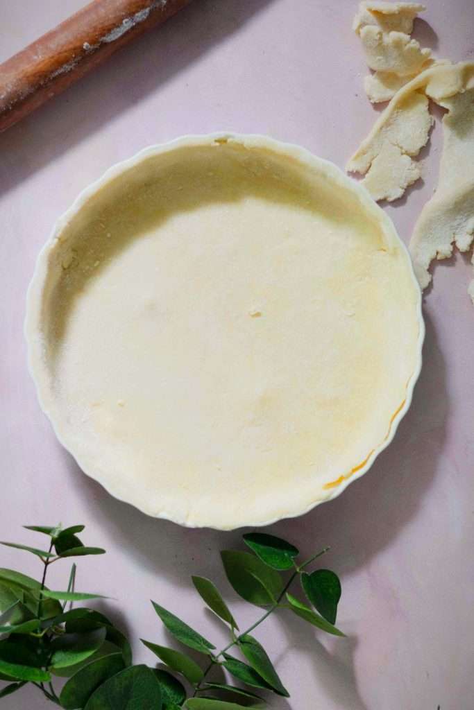 Strawberry rhubarb tart butter pastry dough set in a pie dish.