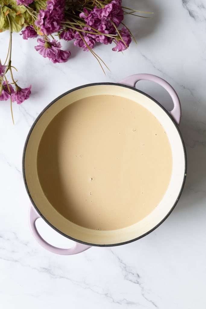 Homemade Coffee Ice Cream with Chocolate & Meringue 13 A shallow cooking pot with a creamy coffee mixture inside.