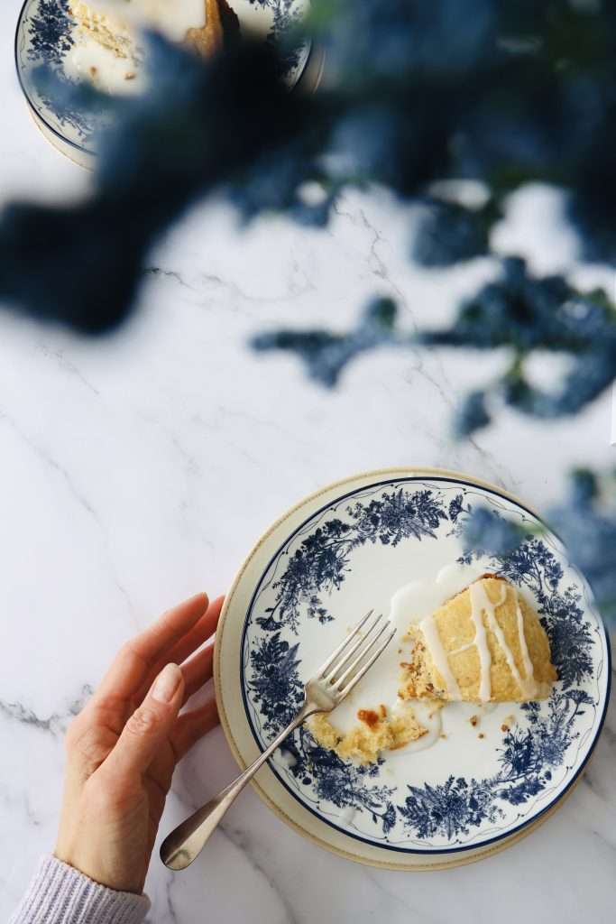 Cinnamon layered scone with vanilla drizzle on a floral plate.