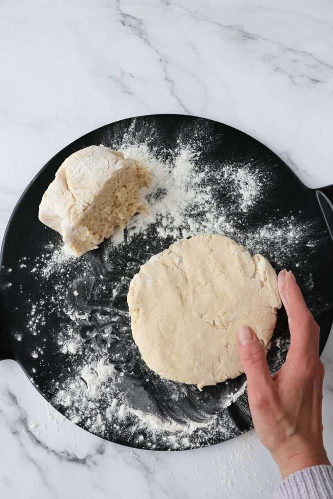 A dough layer for cinnamon layered scones being shaped by hand.