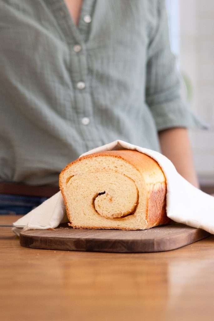 Maple Brioche with a Maple Sugar Swirl 1 A loaf of maple brioche on a cutting board having been sliced to show the maple swirl.
